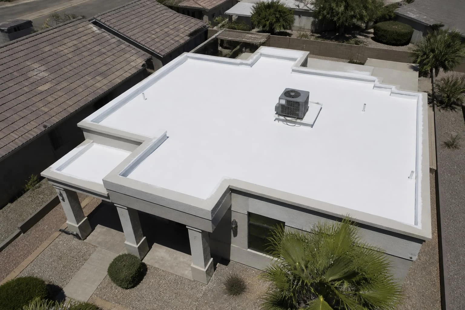 Aerial view of a white foam flat roof with an air conditioning unit