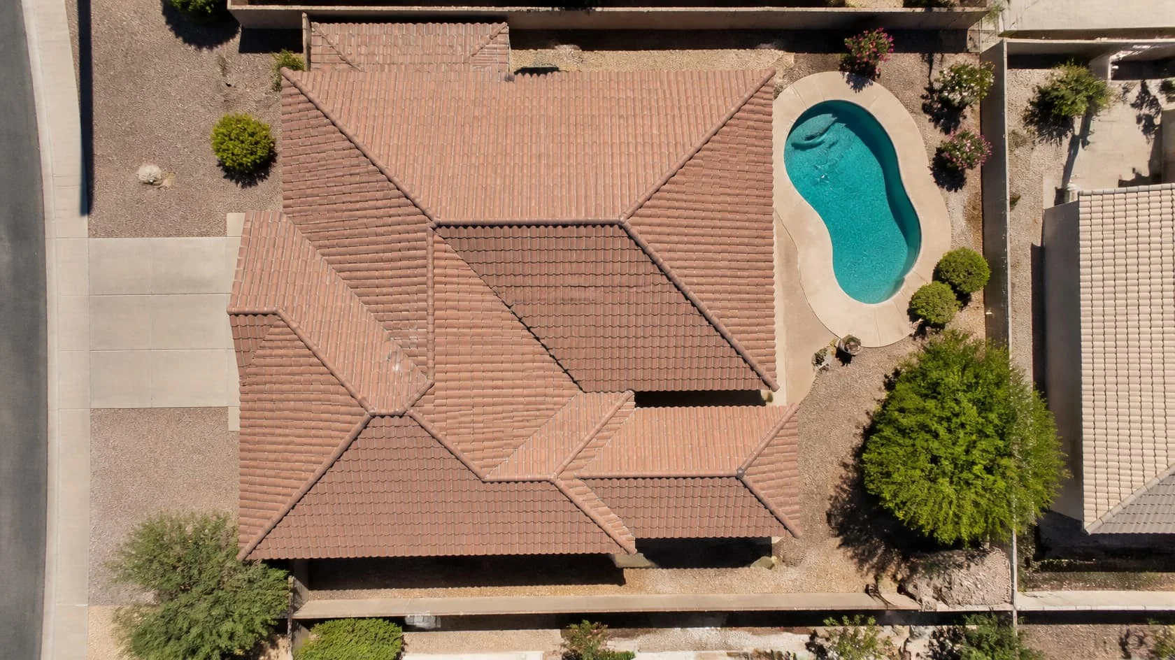 Overhead view of a tile roof and backyard pool